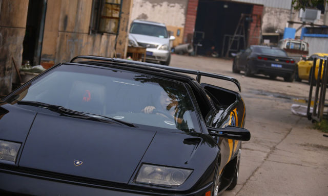 Wang drives a handmade replica of Lamborghini Diablo during a test drive outside a garage on the outskirts of Beijing