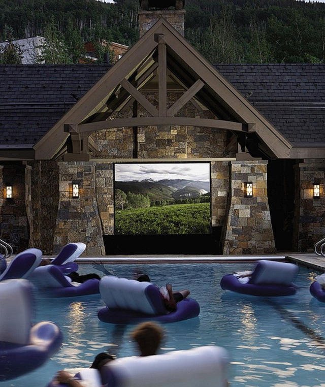 Boiando em uma piscina com um telão de cinema